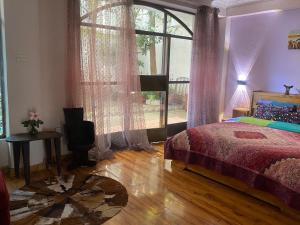 Kefetew Guest House في أديس أبابا: غرفة نوم بسرير ونافذة كبيرة