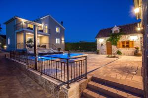 a house with a swimming pool in a yard at VIP Luxury villa with a heated pool and jacuzzi-Granny's Gold in Lovreć