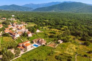 an aerial view of a house in a field with mountains at VIP Luxury villa with a heated pool and jacuzzi-Granny's Gold in Lovreć +47 photos