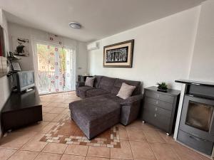 a living room with a couch and a tv at Apartments Roxsi in Novalja
