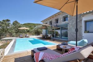 a pool with chairs and an umbrella and a house at Tsakmakis Villas - Luxury - Panoramic Sea View Lefkada in Tsoukalades
