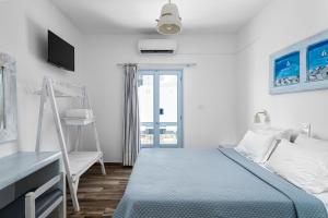 a bedroom with a bed and a desk and a window at Hotel Iris in Naousa