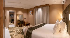 ein Hotelzimmer mit einem großen Bett und einem Schreibtisch in der Unterkunft مستقر للشقق الفندقية الياسمين in Ha'il