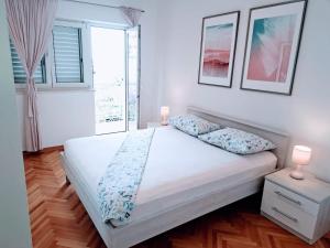 1 dormitorio con 1 cama con 2 lámparas y una ventana en Apartman Nina, en Omiš