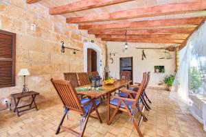 a dining room with a wooden table and chairs at Villa Rural Son Pou in Sa Pobla