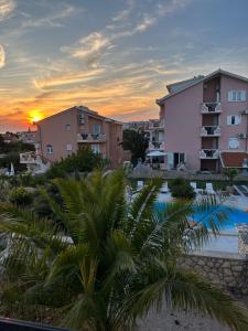 een uitzicht op een resort met een zwembad en gebouwen bij Apartments Roxsi in Novalja