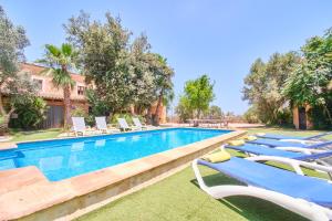 a row of lounge chairs next to a swimming pool at Villa Rural Son Pou in Sa Pobla