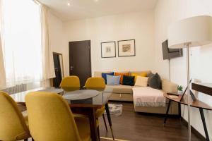 sala de estar con sofá, mesa y sillas en Paulay Design Apartment, en Budapest