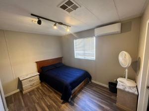 1 dormitorio con 1 cama azul y ventilador en Preciosa casa para 10 personas, en Mexicali