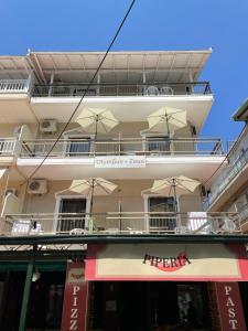 a white building with umbrellas on the balcony at Olympus and Zeus in Olympic Beach