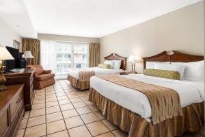 Cette chambre comprend deux lits et une télévision. dans l'établissement Tidelands Caribbean Boardwalk Hotel and Suites, à Ocean City