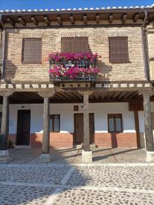 a building with a balcony with flowers on it at Casa Histórica Aldana, Plaza Vieja in Saldaña