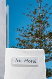 een bord dat zijn hotel naast een boom leest bij Hotel Iris in Naousa