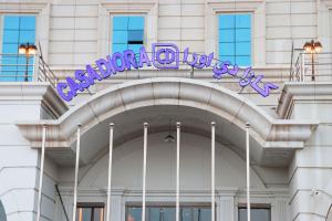 un edificio con un letrero púrpura encima en Casa Diora Hotel Jeddah en Yeda
