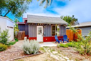 una piccola casa con due sedie blu in un cortile di West Side Cottage a Boise