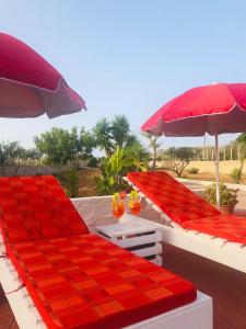 un patio con 2 letti, ombrelloni e tavolo di Casetta del sole a Lampedusa