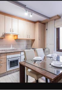 a kitchen with a wooden table and a table and chairs at Apartamento Maite Jiménez in Alhaurín el Grande