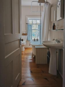 a bathroom with a tub and a sink and a toilet at The Cooper's Inn in Shelburne