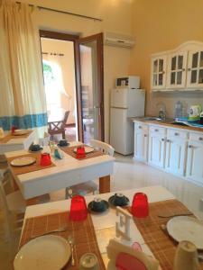 アルゲーロにあるb&b Artemisiaの白いキャビネット、テーブルと椅子付きのキッチンが備わります。