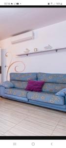 a blue couch with a purple pillow on it at Apartamento Maite Jiménez in Alhaurín el Grande