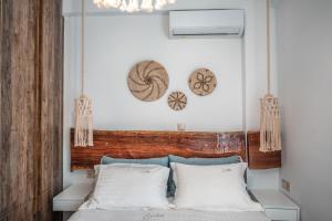 um quarto com uma cama e uma cabeceira em madeira em Epithea Suites Kythnos 1 με ιδιωτική πισίνα em Kythnos