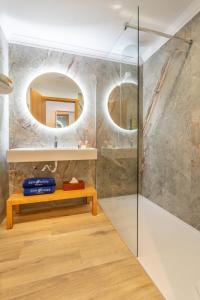 a bathroom with a bench and a mirror at Studios by Aqua Natura Hotels in Porto Moniz