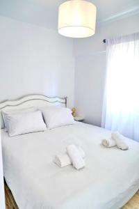 a bedroom with a white bed with two towels on it at GK - Modern Apartment in Nafpaktos