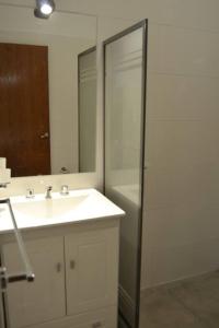 uma casa de banho com um lavatório e um chuveiro com um espelho. em Almirante Brown 235 , Dpto 5 em San Martín