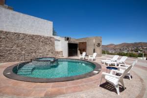 a swimming pool with white chairs and a building at Casa de Tillie in Guanajuato