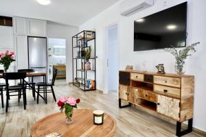 uma sala de estar com uma mesa e uma televisão em GK - Modern Apartment em Lepanto