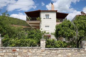 a house on a hill with a stone wall at GK - Modern Apartment in Nafpaktos