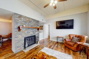 uma sala de estar com uma lareira de tijolos e um sofá em Grandfather View em Sugar Mountain