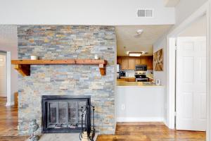 a brick fireplace in a living room with a stone wall at Grandfather View in Sugar Mountain