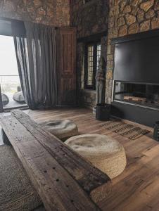 a living room with two stools and a fireplace at Three Dots Boutique Suites in Soúlion