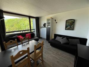 a living room with a table and a couch at Appartement Les Menuires, 2 pièces, 4 personnes - FR-1-452-19 in Les Menuires