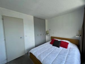 a bedroom with a bed with red and black pillows at Appartement Les Menuires, 2 pièces, 4 personnes - FR-1-452-19 in Les Menuires