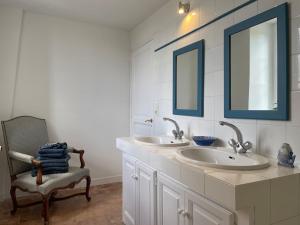 La salle de bains est pourvue de 2 lavabos, d'une chaise et de 2 miroirs. dans l'établissement Maison de Famille près de Montargis - Élégance et Confort en Forêt - FR-1-590-354, à Paucourt 23 autres photos