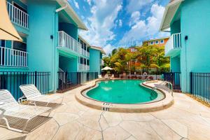 a swimming pool in the middle of a courtyard with two buildings at Highland Avenue Heaven in Bradenton Beach