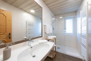 Baño blanco con lavabo y espejo en Eden Appartements en Going