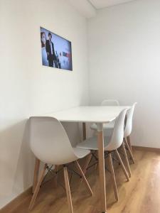 un tavolo con sedie bianche e una foto sul muro di Lisbon South Bay Apartment with terrace ad Almada