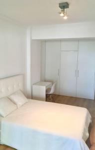 a bedroom with a white bed and a desk at Lisbon South Bay Apartment with terrace in Almada