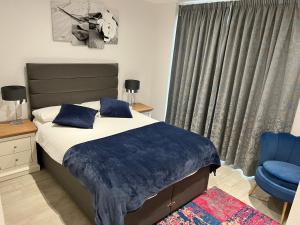 イーストボーンにあるRegent Hotelのベッドルーム1室(ベッド1台、青い椅子付)