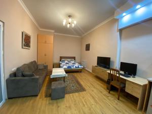 a living room with a couch and a bed at Studio apartment in Yerevan in Yerevan