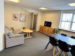 an office with a couch and a table and a tv at City 6-bedroom gammel in Aalborg