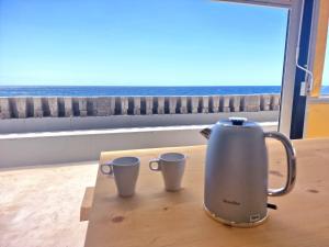 a tea kettle and two cups sitting on a table at Boutique Hotel Las Eras Beach in Las Eras