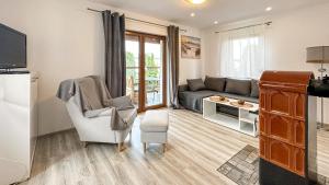 a living room with a couch and a chair at Białe Żagle - domki nad morzem in Kopań