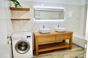 uma casa de banho com 2 lavatórios e uma máquina de lavar roupa em GK - Modern Apartment em Lepanto