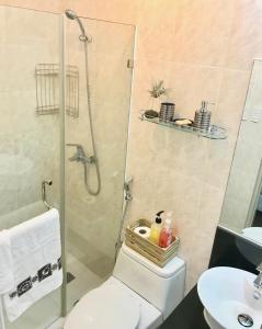een badkamer met een douche, een toilet en een wastafel bij Manila Airport Staycation near NAIA Terminal 3 in Manilla