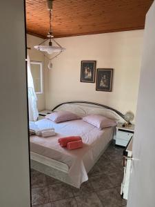 1 dormitorio con 1 cama grande con almohadas rosas en Vila Katerina Anna, en Nea Kalikratia