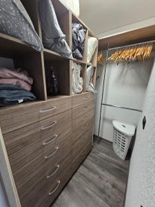 sypialnia z drewnianymi szafkami i toaletą w kabinie w obiekcie Maya's Apartment w Wilnie